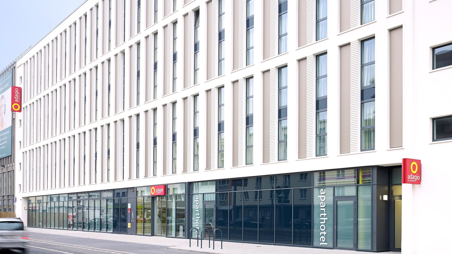 Das Aparthotel Adagio entlang der Straße mit dem Werbeschild an der Ecke