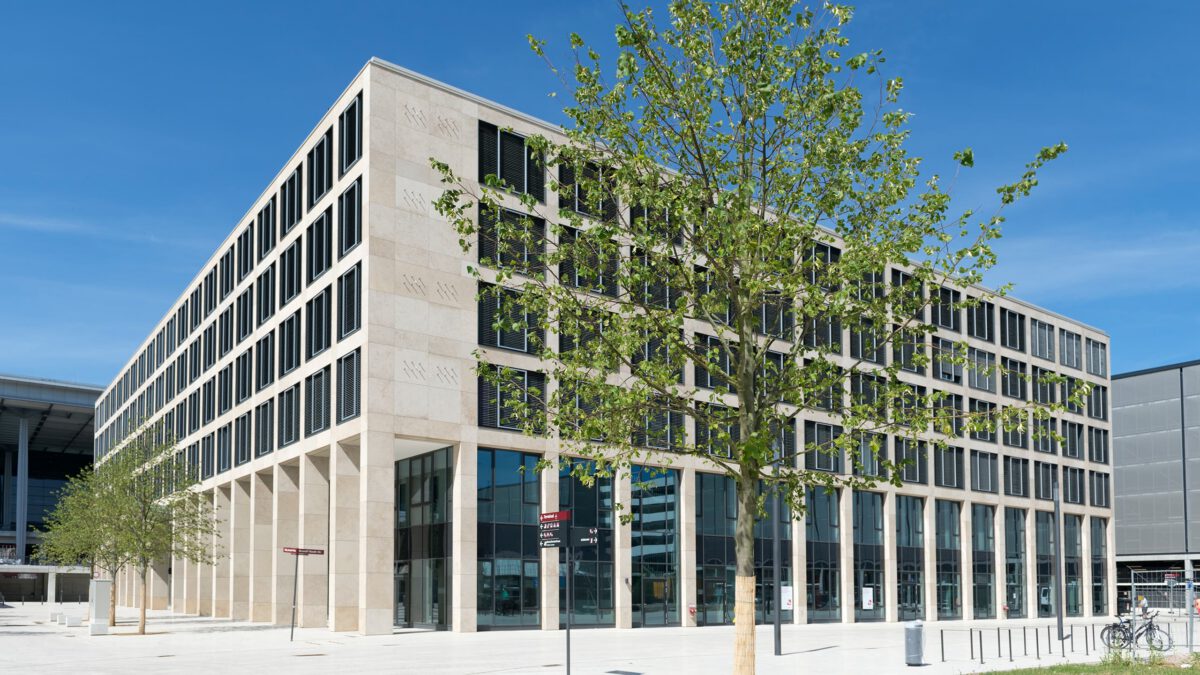Berlin-Brandenburg Airport Center, Gesamtansicht des Bürogebäudes mit Natursteinfassade und Arkadengang