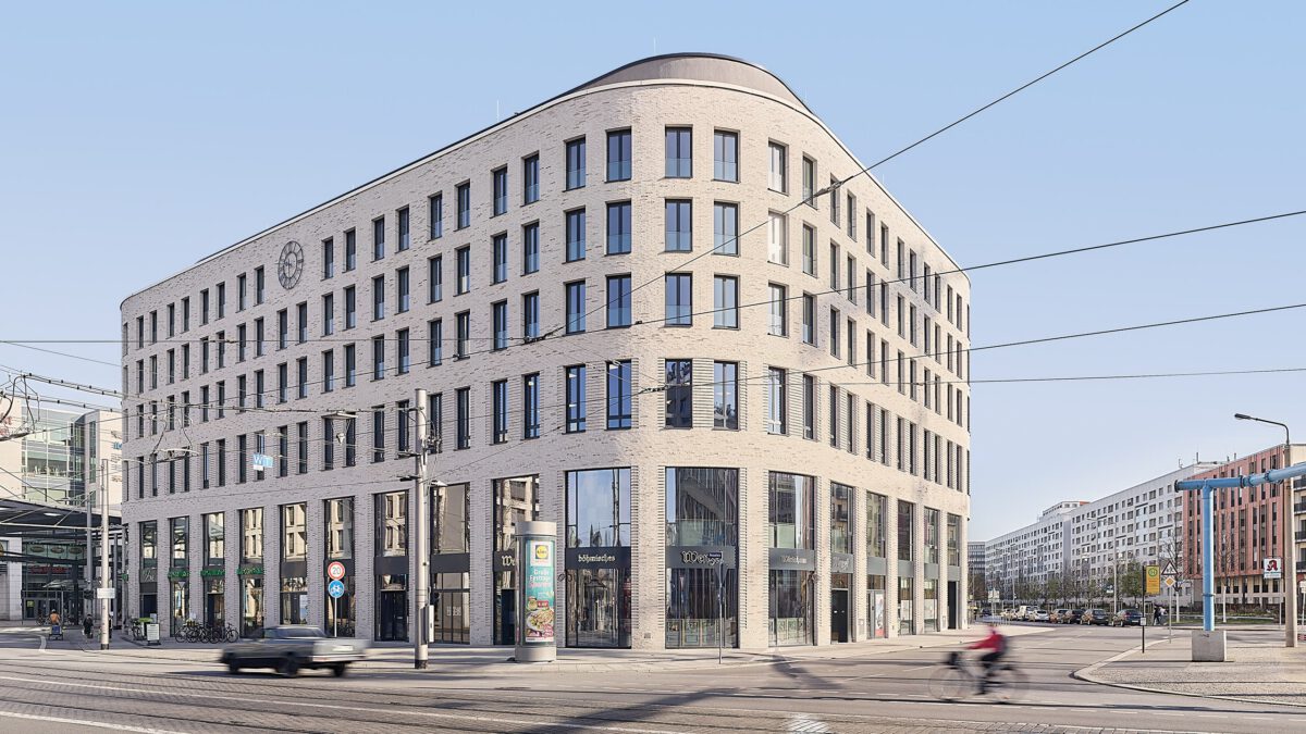 HAUS POSTPLATZ in Dresden, das Klinkergebäude an der Kreuzung mit den Gleisen davor