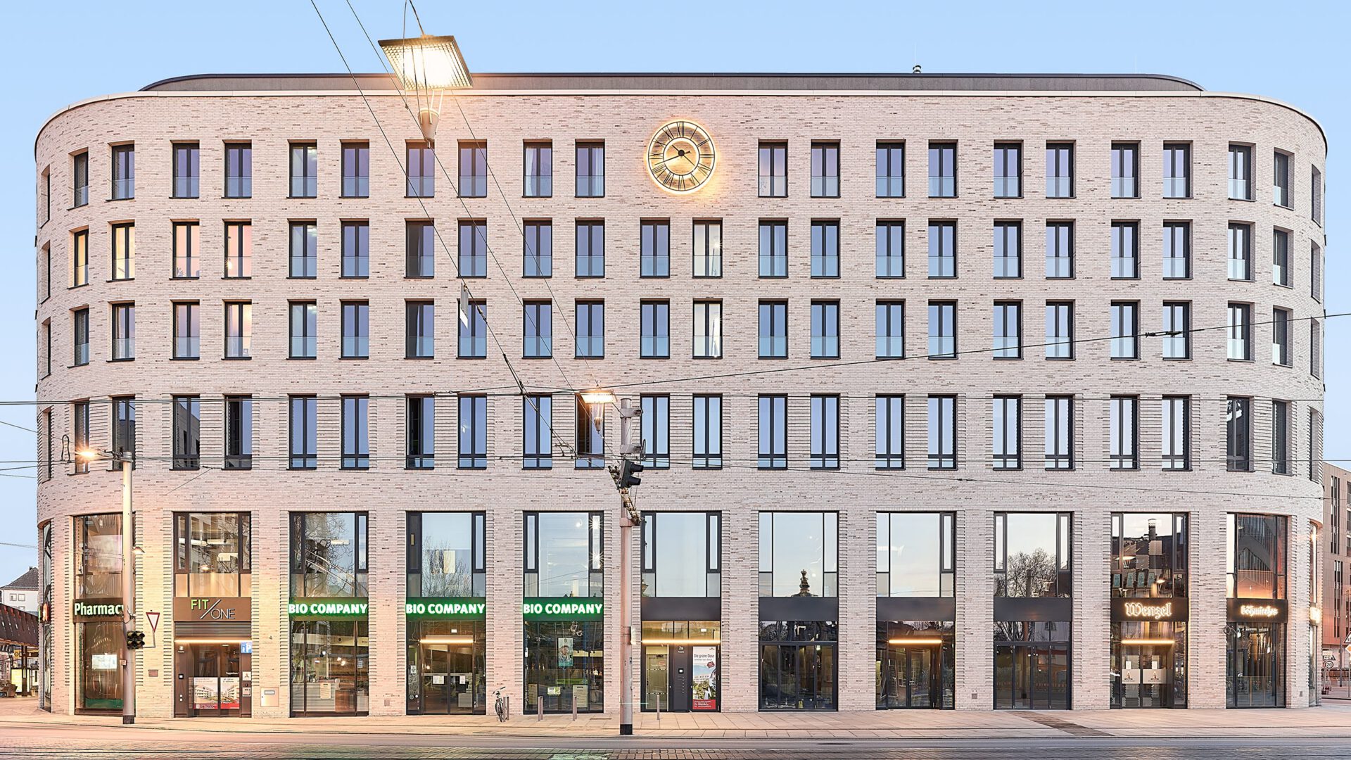 HAUS POSTPLATZ im Abendlicht mit den Ladenflächen im Erdgeschoss