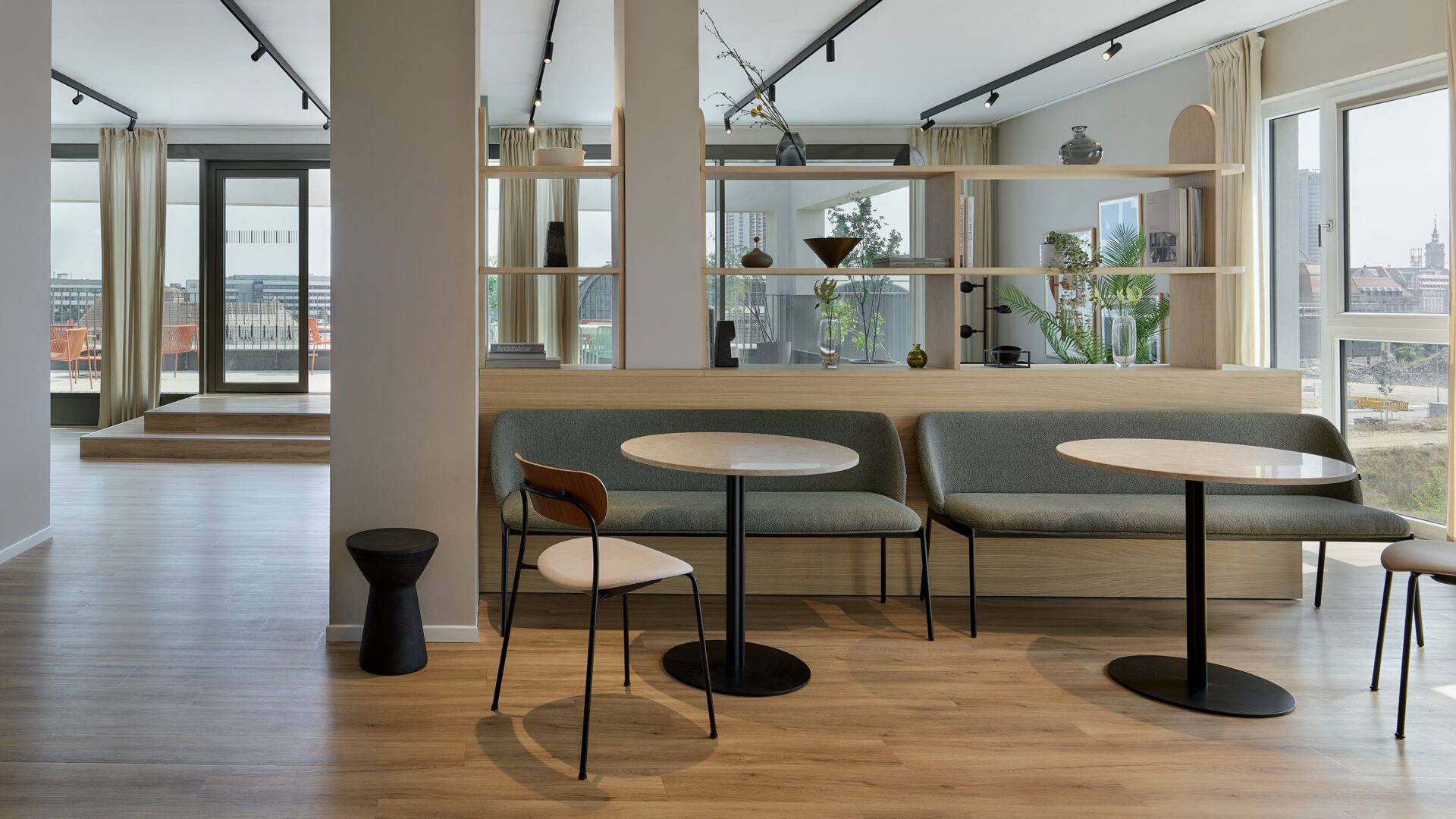 Gemeinschaftsraum im Co-Living mit Sitznischen und Blick über die Stadt