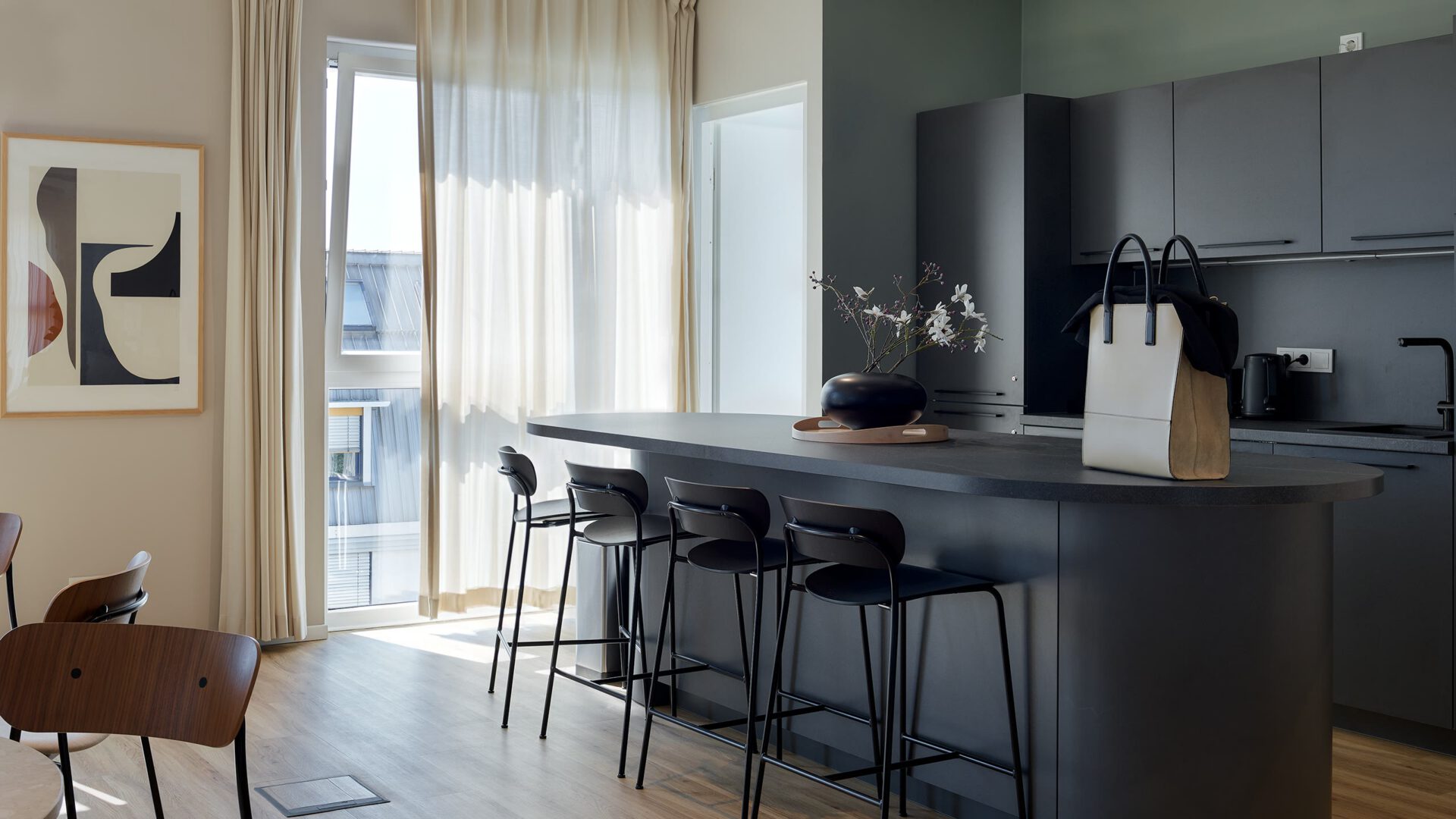 Wohnküche einer Co-Living-Einheit mit Kücheninsel und Barhockern