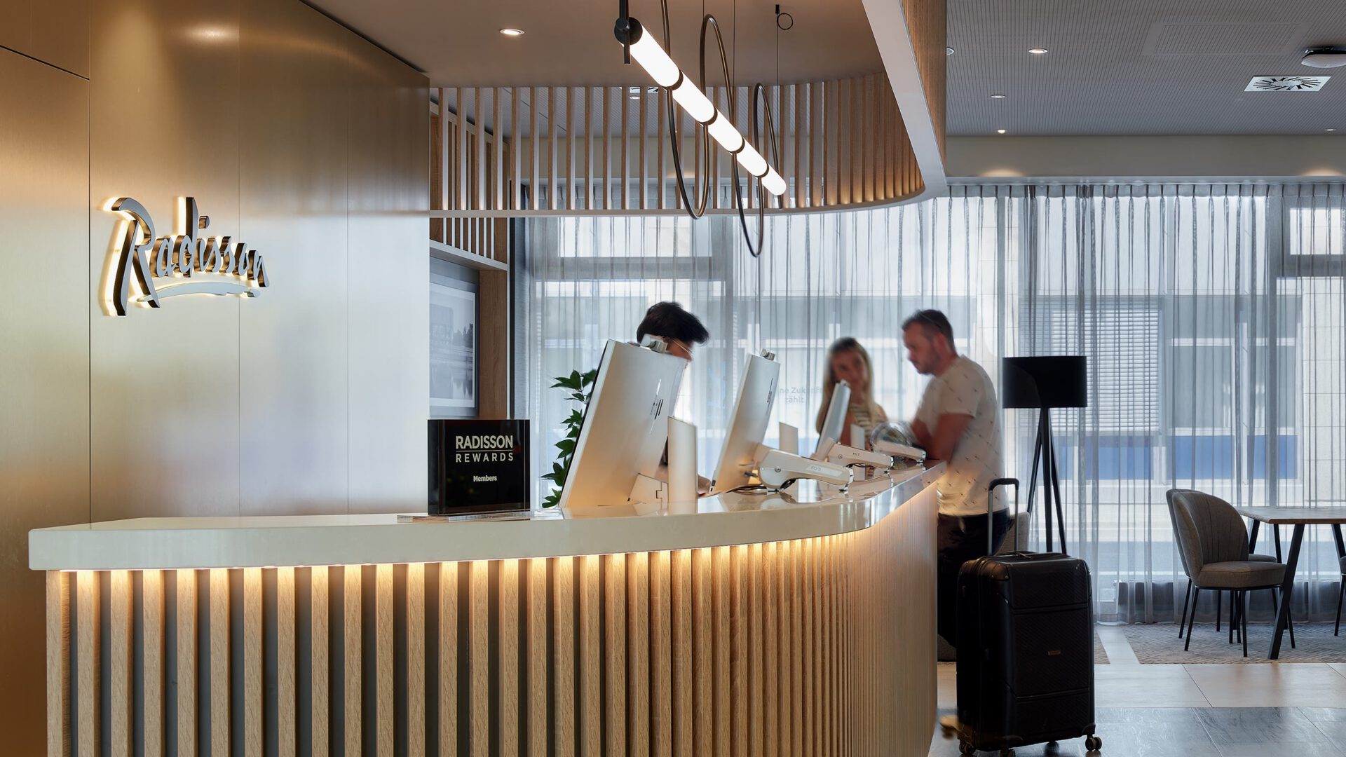 Rezeption des Hotels mit Gästen beim Einchecken