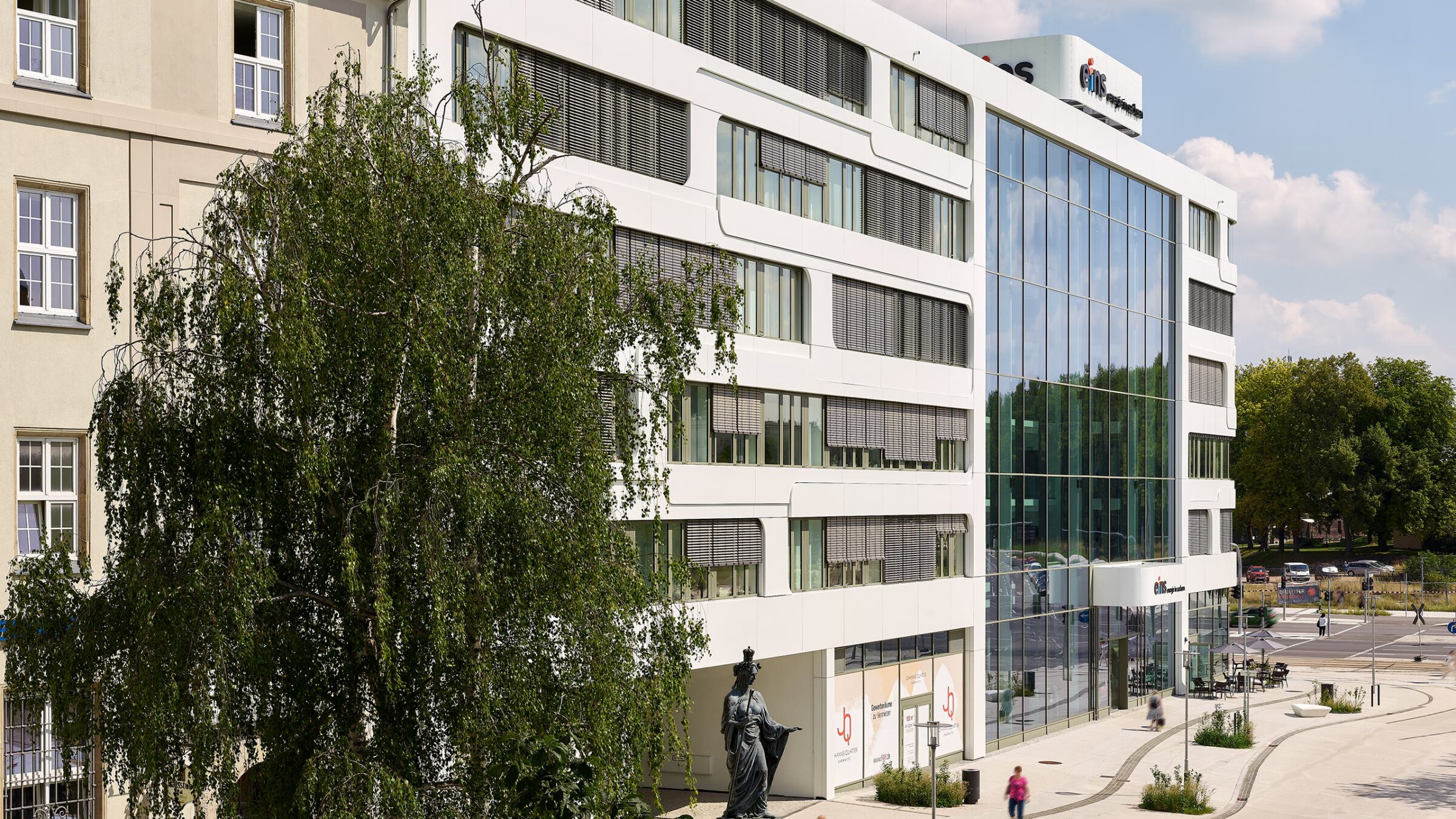 Johannis-Quartier in Chemnitz, das Bürogebäude von eins energie hinter einer Trauerweide