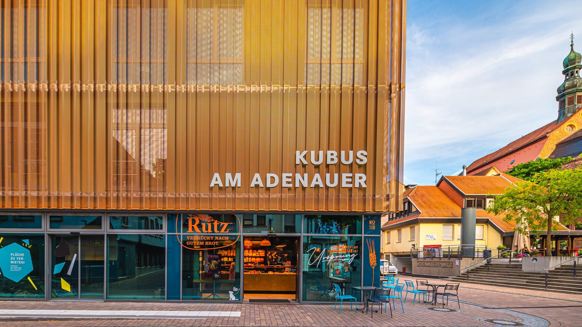 Lamellenfassade des KUBUS AM ADENAUER, rechts die Altstadt mit Kirchturm