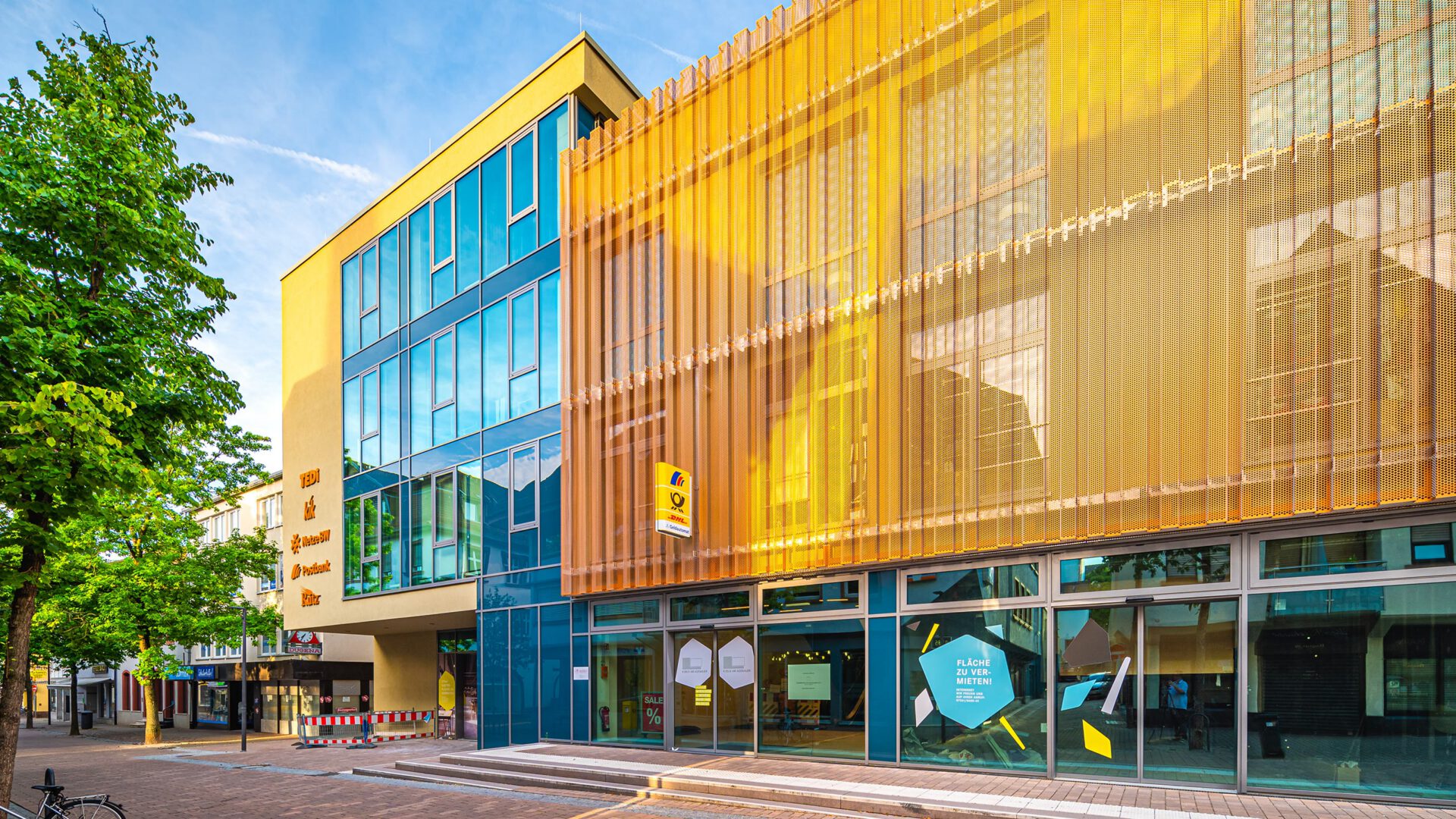 Blau und gelb gefasste Seitenfassade des KUBUS AM ADENAUER