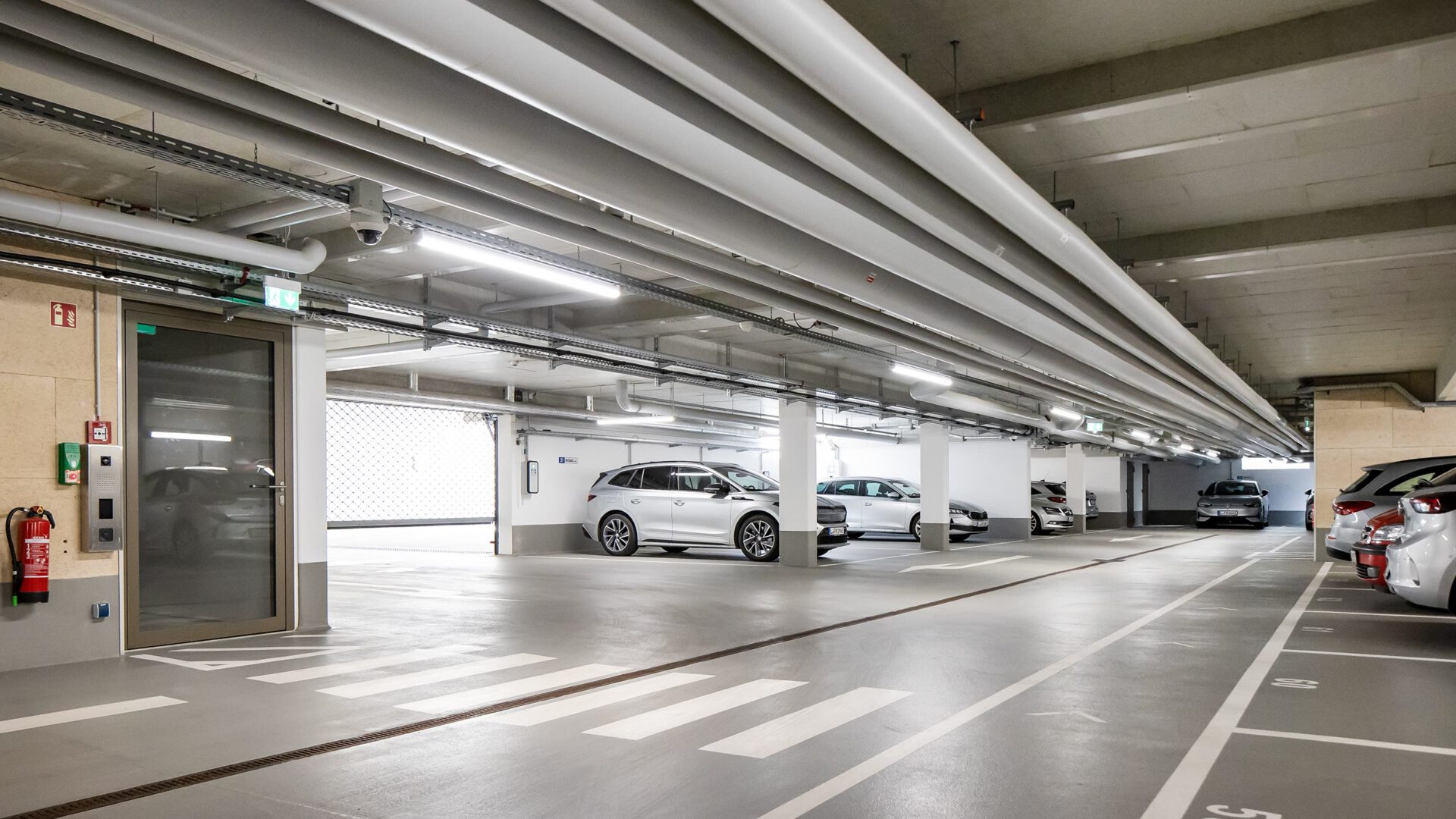 Tiefgarage von MITZSCH mit markierten Stellplätzen und Zugang zum Treppenhaus
