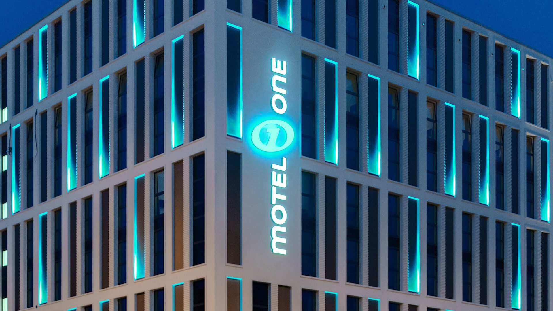Leuchtender Schriftzug Motel One an der Gebäudeecke