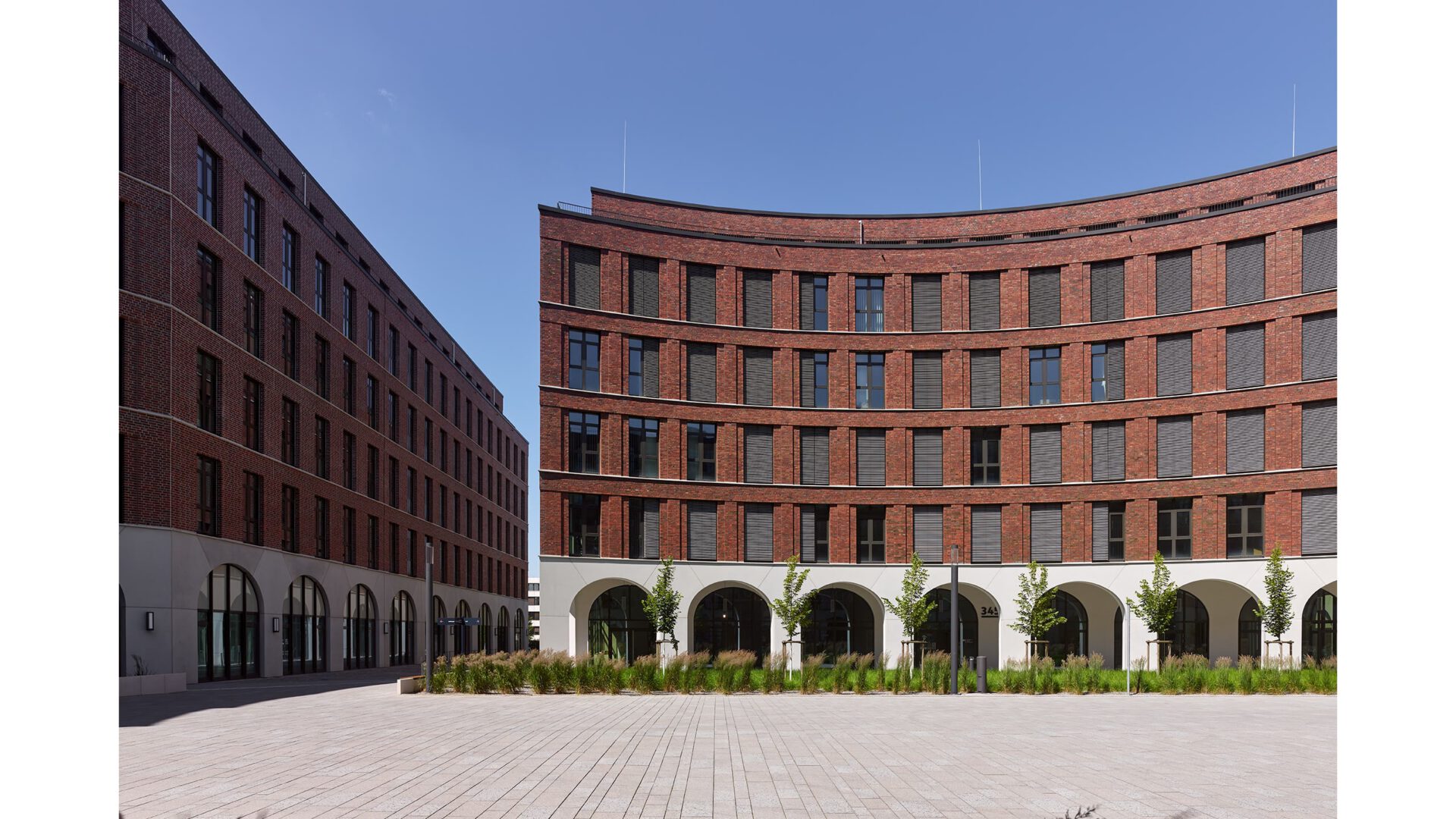 Blick über den Platz auf die gerundete Backsteinfassade von OVUM