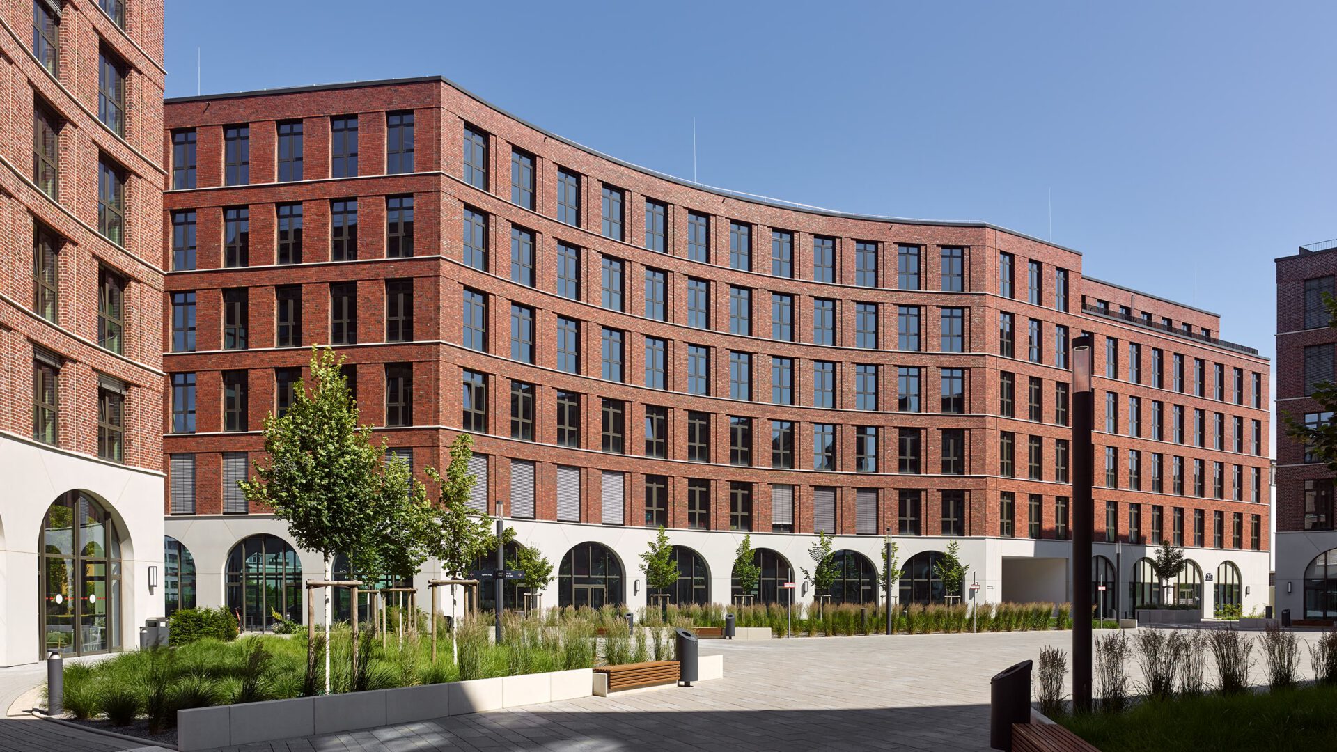 Weite Ansicht des Quartiersplatzes von OVUM mit den umlaufenden Arkaden