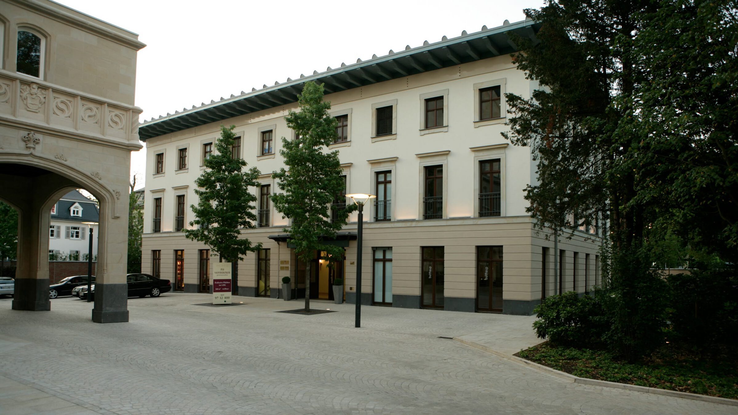 Palais 22 in Frankfurt am Main, der beleuchtete Innenhof am Abend mit dem Torbogen rechts