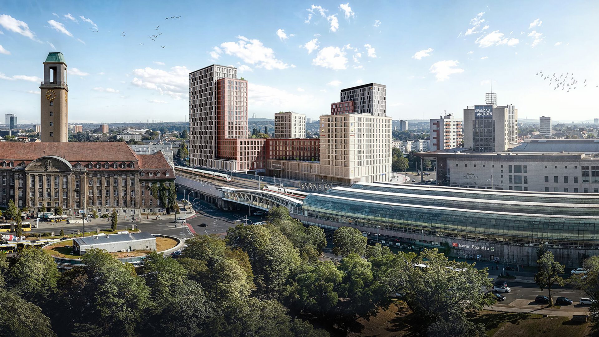 Luftaufnahme mit dem Rathausturm Spandau im Vordergrund und dem Quartier hinter dem Bahnhof