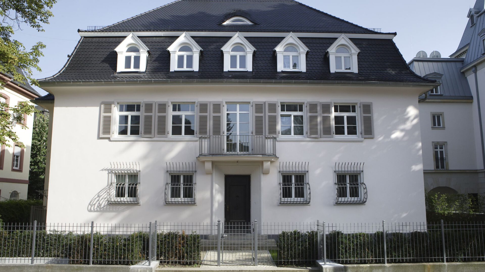 Frontalansicht der Villa, gerahmt vom Baumbestand des Grundstücks