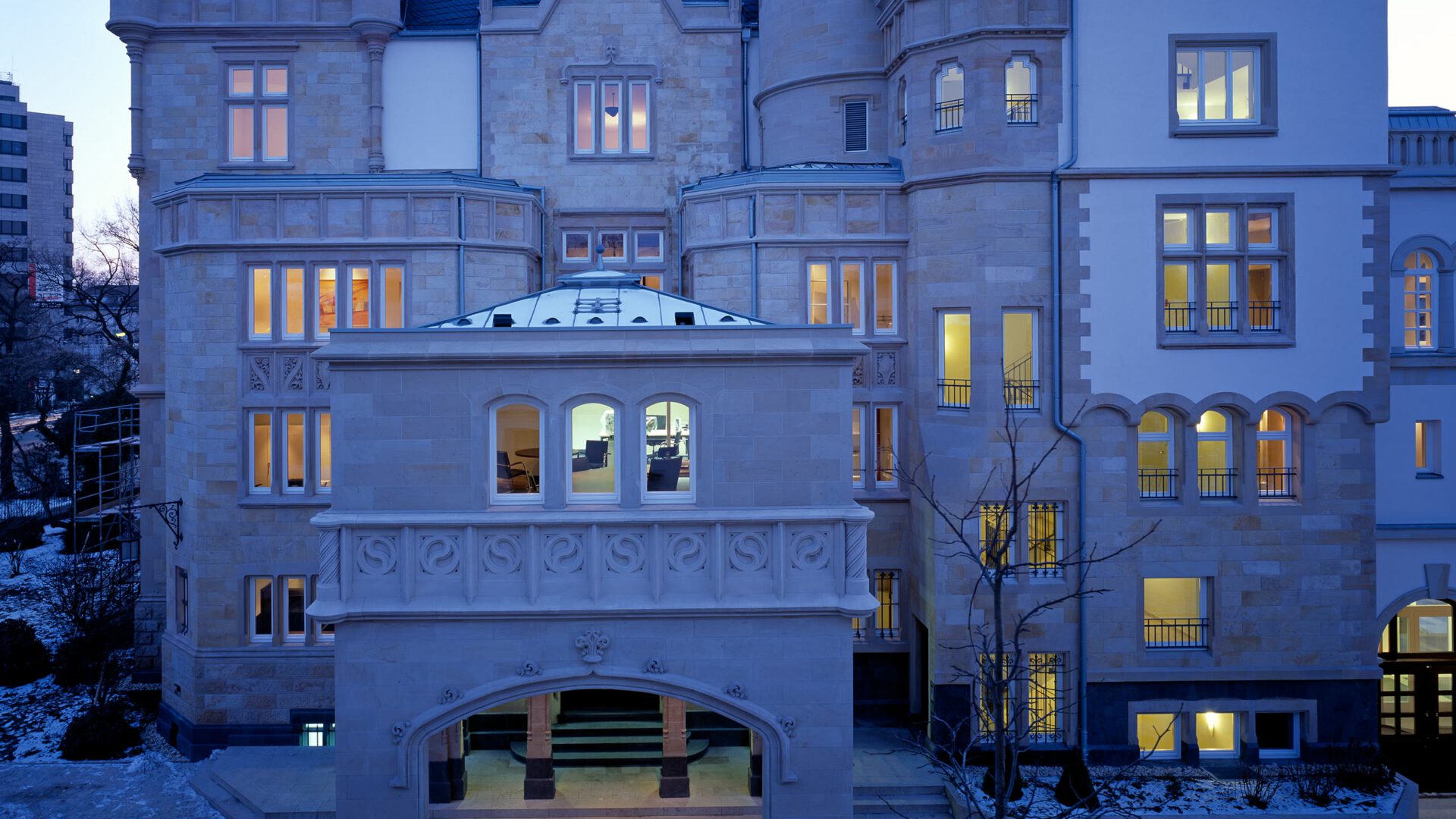 Hoffassade der Villa Kennedy am Abend mit beleuchtetem Wintergarten